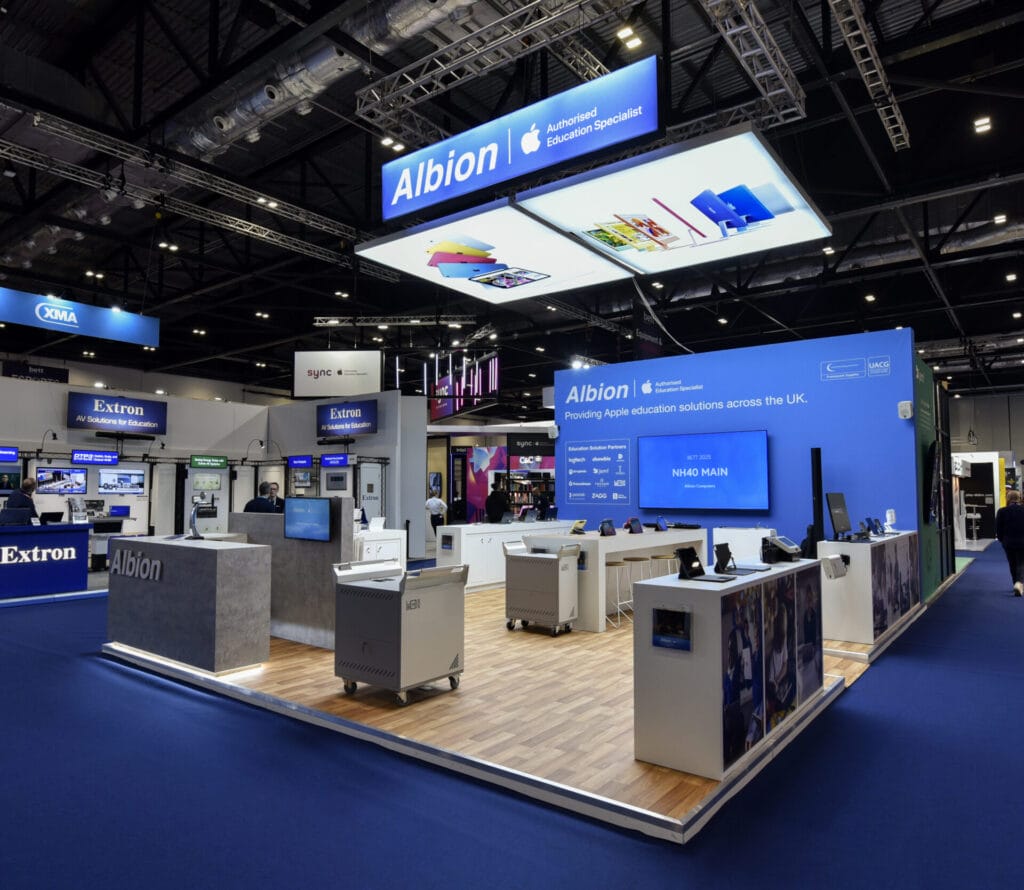 Albion exhibition stand showcasing Apple education solutions, blue branded walls, demo screens, and product display counters